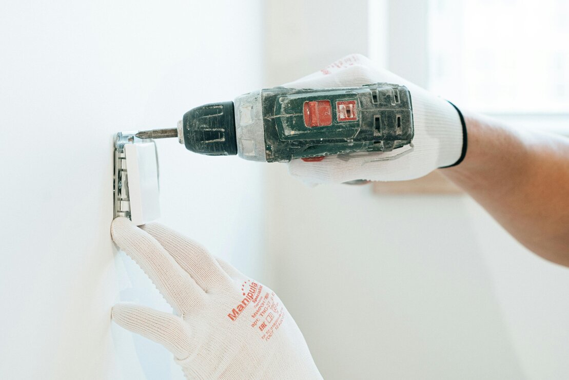 Handwerker führt eine kleine Reparatur an einer Tür durch
